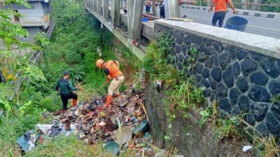 Petugas Gabungan Evakuasi Sampah yang Menggunung di Tebing Sungai Cigunung
