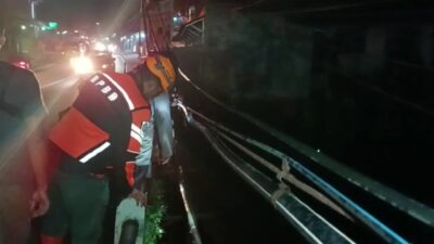 Relawan dan warga melakukan pencarian terhadap korban petugas pemeriksa jembatan yang tersapu banjir bandang