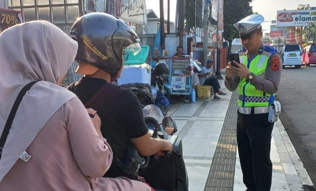Anggota Satlantas Polres Sukabumi Kota saat melakukan penindakan pelanggaran lalu lintas dengan menggunakan Electronic Traffic Law Enforcement (ETLE). Foto: Nuria Ariawan/HALOSMI.