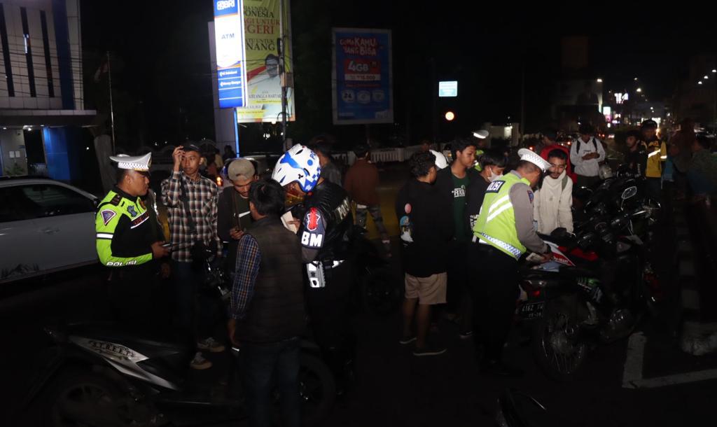Petugas gabungan melakukan penindakan terhadap para pengendara sepeda motor yang kedapatan menggunakan knalpot brong pada Sabtu malam, 18 November 2023. Foto: Nuria Ariawan/HALOSMI.