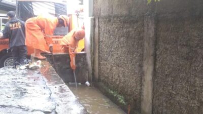 Sigap! Petugas BPBD Evakuasi Sampah Sumbat Saluran Air di Jalan RA Kosasih