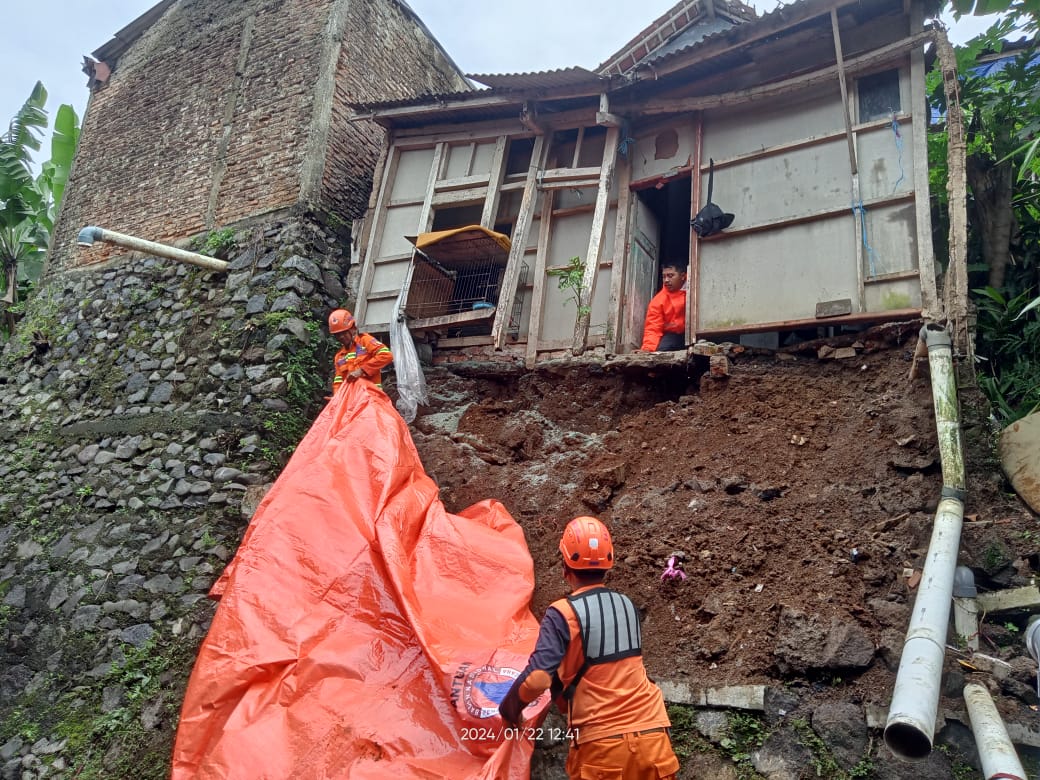 Petugas BPBD Kota Sukabumi melakukan penanganan satu unit rumah warga yang dikhawatirkan tergerus longsoran, di wilayah Kelurahan Sriwedari, Kecamatan Gunungpuyuh, pada Senin, 22 Januari 2024. Foto Pusdalops BPBD Kota Sukabumi for HALOSMI.