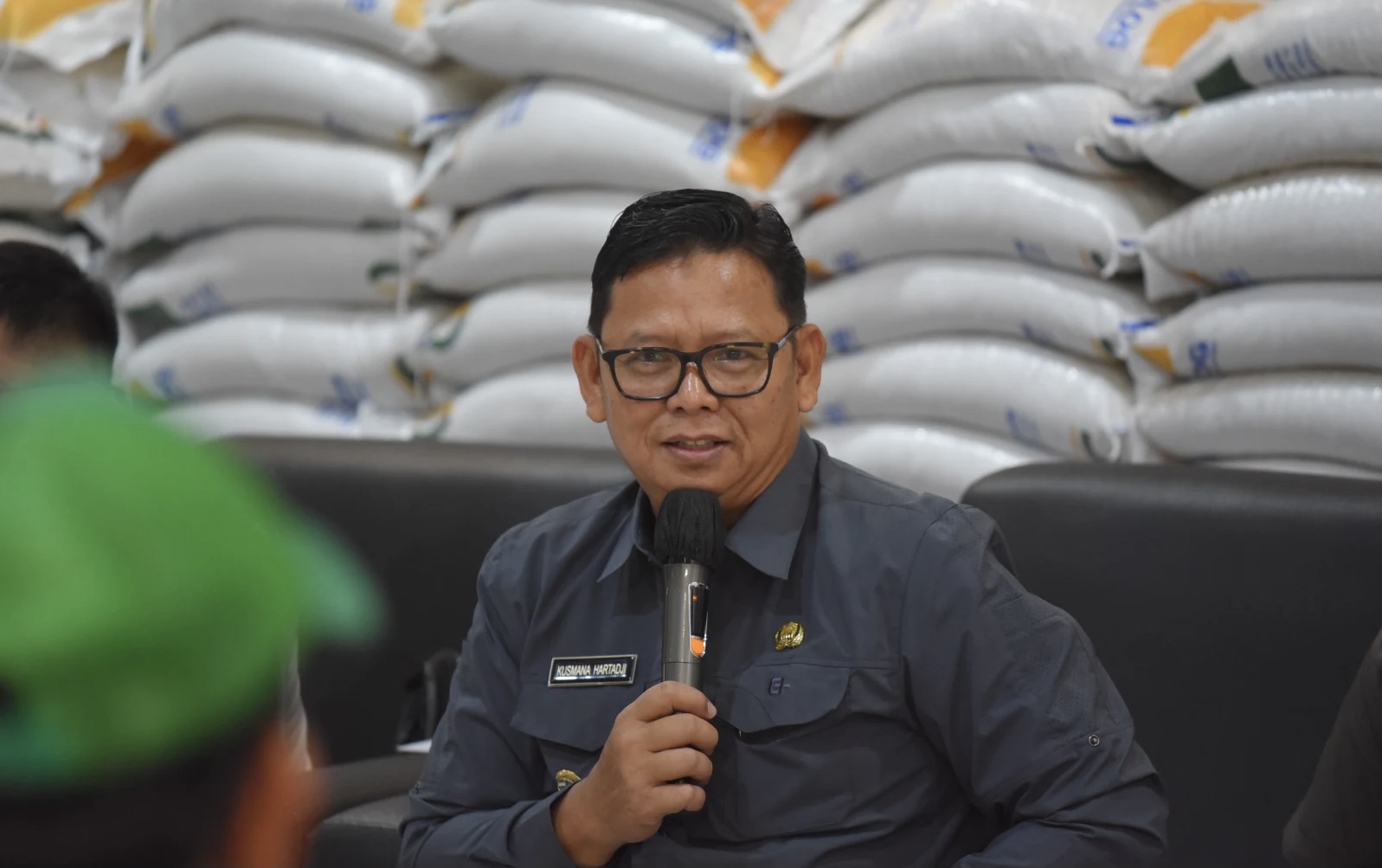 Pj Wali Kota Sukabumi, Kusmana Hartadji, saat memberikan sambutan dalam kegiatan penyerahan bantuan pangan beras secara simbolis kepada 1.070 KPM di Kelurahan Limusnunggal, pada Selasa, 7 Mei 2024. Foto: Dokpim Kota Sukabumi.