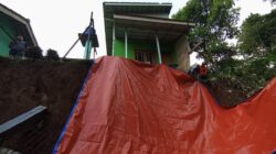 Petugas BPBD Kota Sukabumi memasang terpal di lokasi TPT ambruk di Jalan Aminta Azmali RT 03/08 Kelurahan Sriwedari, Kecamatan Gunungpuyuh, pada Jumat, 17 Mei 2024. Foto: Pusdalops BPBD Kota Sukabumi for HALOSMI.